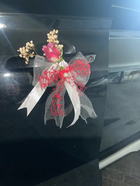 Décoration de capot avec fleurs rouges et rubans blancs à Tetouan
